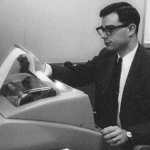 An image depicting Allan Scherr, a pioneering figure in cyber history, engaged with early computing equipment, showcasing his innovative contributions during the 1960s